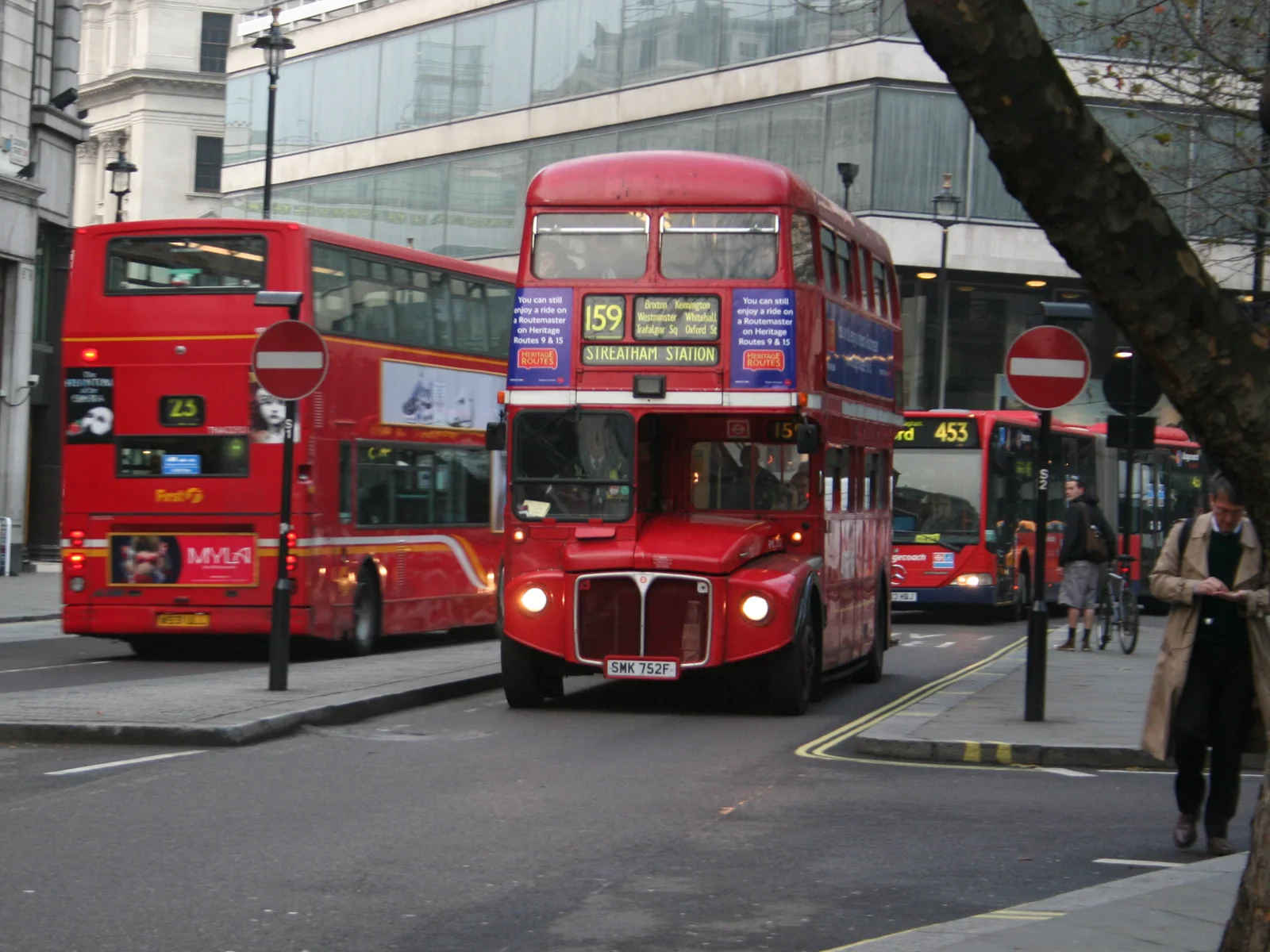 London Routemaster Bus: A red double-decker bus with repeated windows, a high upper deck, stairs, and a rear platform.