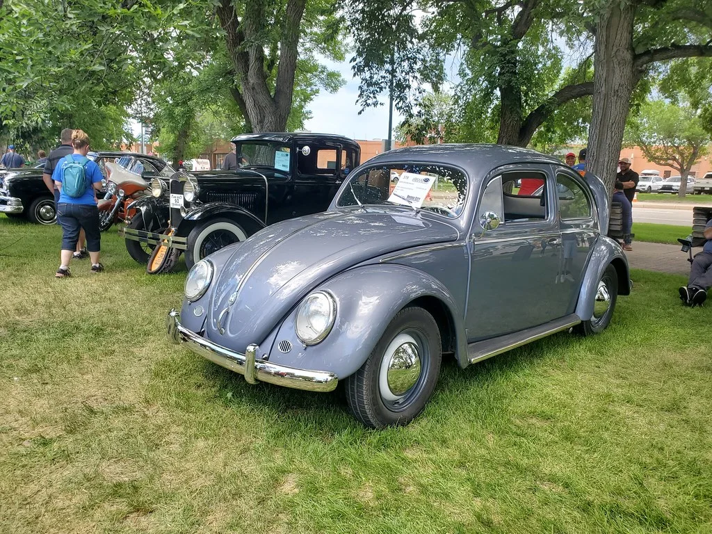 Volkswagen Beetle: A compact rounded car with curved roof, separate fenders, circular lamps, and a high-sided body.