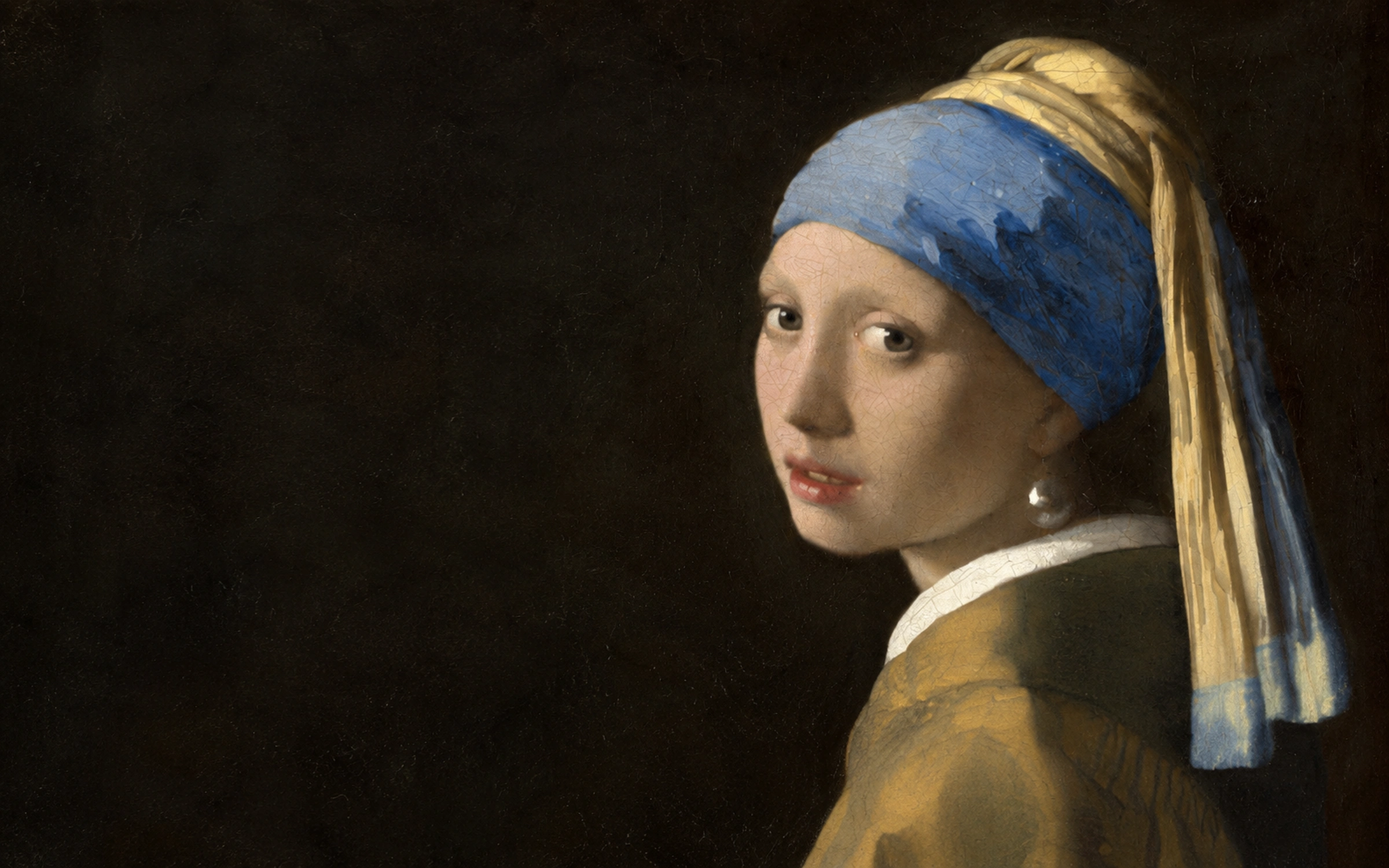 Girl with a Pearl Earring by Johannes Vermeer: a young woman turns toward the viewer, wearing a blue and gold headscarf and a pearl earring.